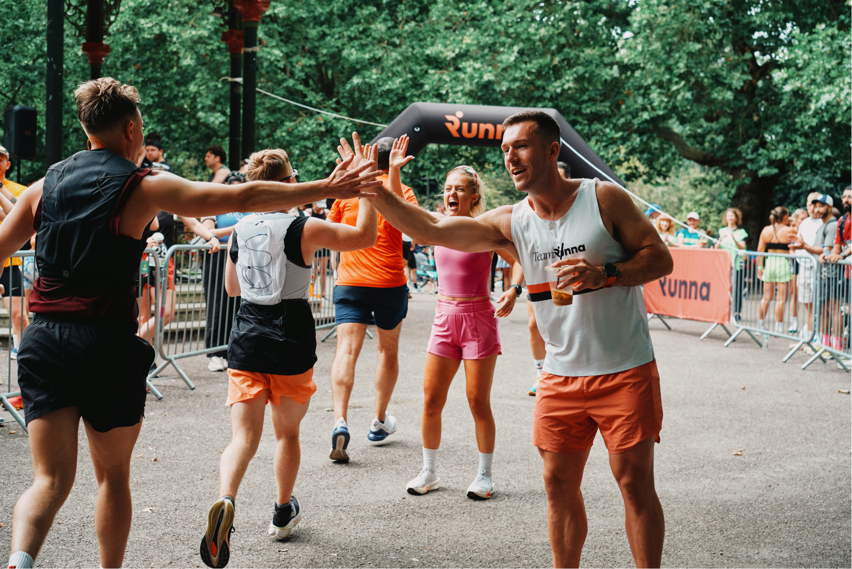 Runner's high fiving each other at a race finish line.